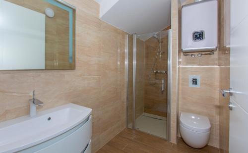 ein Badezimmer mit Dusche, Toilette und Waschbecken in der Unterkunft Luxury Aparthotel in Makarska
