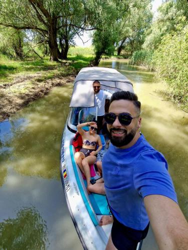 a man and two people in a boat on a river at Delta MEO in Mahmudia