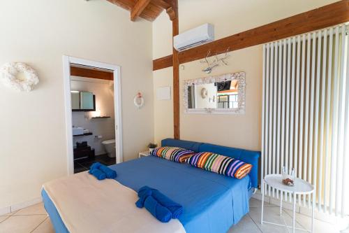 a bedroom with a blue bed and a table at Blue Moon Relais in Santa Maria di Scacciano