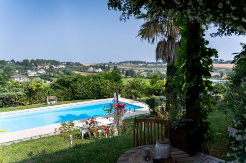 vistas a la piscina desde el patio de una casa en Blue Moon Relais, en Santa Maria di Scacciano