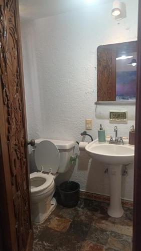 a bathroom with a toilet and a sink at Bonanza Garden Suite s in Cuernavaca