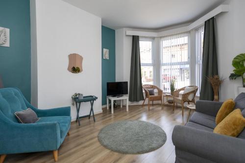 a living room with a couch and chairs and a tv at Glenmore Lodge in Belfast