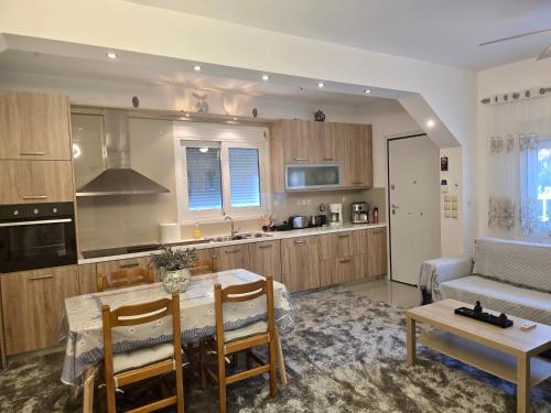 a kitchen and living room with a table and a couch at Sofia's Seaview Villa Near Airport And Beach in Artemida