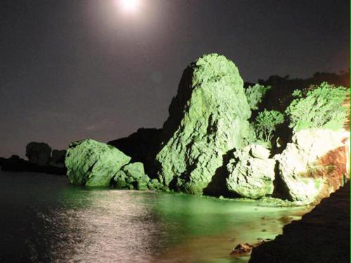 a large rock formation in the water at night at Saint George Hotel in Rodakino