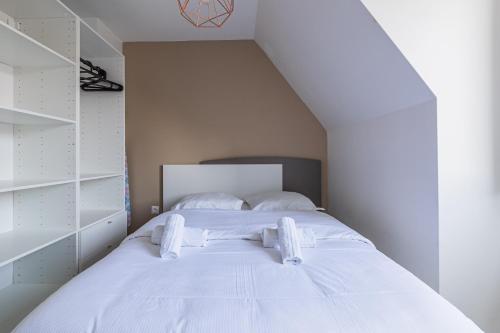 a bedroom with a white bed with white shelves at L'Escapade Strasbourgeoise - Magnifique petit T2 refait à neuf in Strasbourg