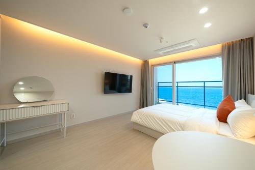 a bedroom with a bed and a large window at DIAMER Hotel Sokcho by AankStay in Yangyang