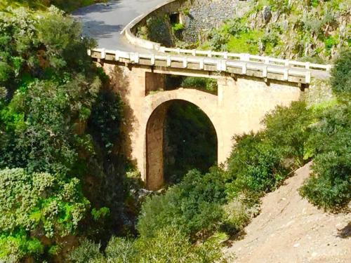 a bridge with a train on it on a road at Saint George Hotel in Rodakino