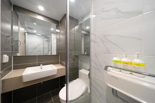 a bathroom with a sink and a toilet and a mirror at DIAMER Hotel Sokcho by AankStay in Yangyang