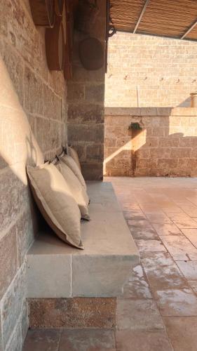 two pillows sitting on a bench in a brick wall at Borgo Don Ciccio in Felline