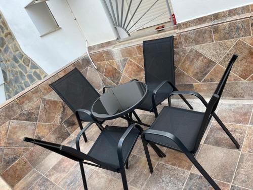 three black chairs sitting on a tiled floor at Apartamento tranquilo y luminoso in Arcos de la Frontera