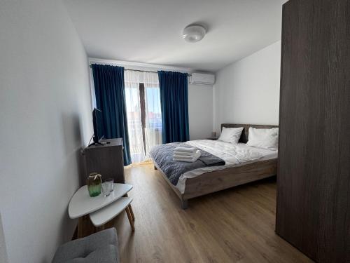 a bedroom with a bed and a window with blue curtains at Delta MEO in Mahmudia