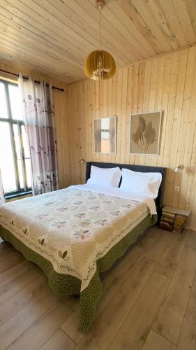 a bedroom with a large bed in a room with wooden walls at SouthLux3 in Tossor
