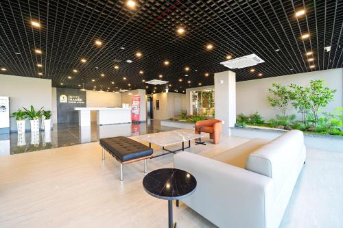 a lobby with a white couch and a table at DIAMER Hotel Sokcho by AankStay in Yangyang