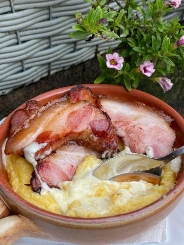 una ciotola di cibo con un pezzo di carne sopra di Hanul Drumul Talienilor a Văleni-Stînişoara