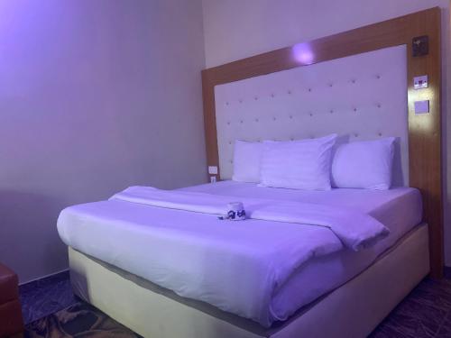 a bed in a hotel room with a camera on it at Beamgate Hotels & Apartments, Abak Rd, Uyo in Uyo