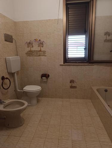 a bathroom with a toilet and a bath tub at Villa Giardini in Balestrate