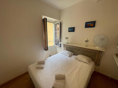 une chambre avec un lit blanc avec une fenêtre dans l'établissement smichel view, à Menton