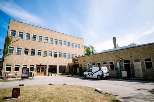 a white van parked in front of a brick building at Second Home Apartments Asplund in Solna