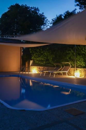 a swimming pool at night with a table and a bench at Podere Quartarola in Modigliana