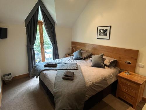 a bedroom with a large bed and a window at 6, The Gallops, Mains of Taymouth Estate, Kenmore in Kenmore