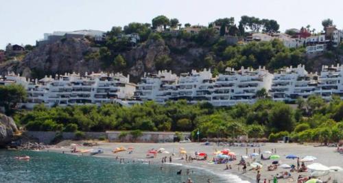 a group of people on a beach with buildings at El Cortijillo 503 in Almuñécar