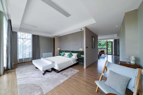 a bedroom with a large white bed and a couch at Chengdu Flowing Strings peninsula boutique hotel-Near the Sichuan Cuisine Museum in Chengdu