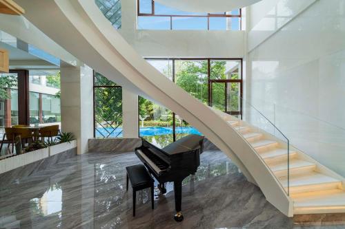 a grand piano in a room with a staircase at Chengdu Flowing Strings peninsula boutique hotel-Near the Sichuan Cuisine Museum in Chengdu