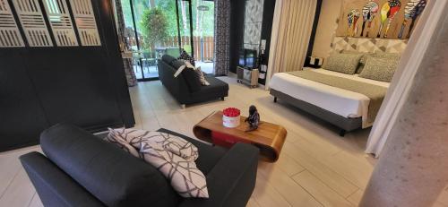 - un salon avec deux canapés et un lit dans l'établissement La chaume du marais poitevin avec barque green venice with boat, à Sansais