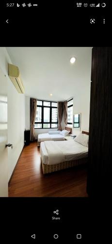 a bedroom with two beds and a large window at Lake view homestay in Serdang