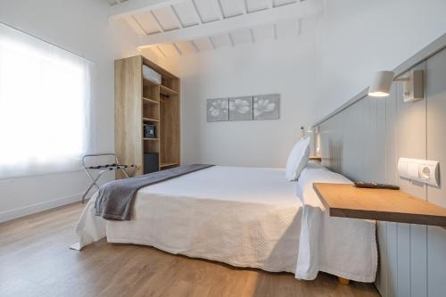 a bedroom with a large white bed and a window at Agroturismo Santa Mariana in Alaior