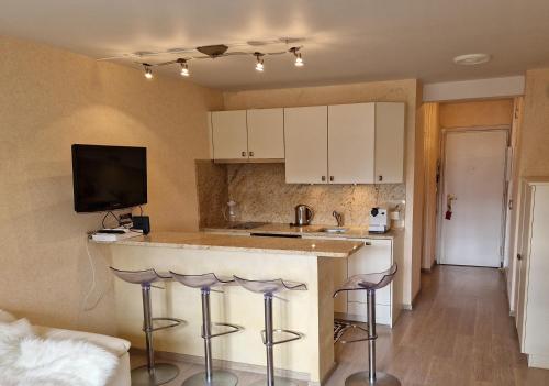 une cuisine avec un comptoir et des tabourets dans une pièce dans l'établissement Charmant studio Deauville, proche plage avec parking privé, à Deauville