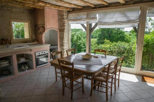 Una cocina y un comedor con mesa y sillas. en Restored 18Th Century Farmhouse Near Albi, en Rouffiac