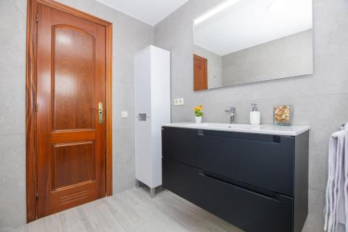 Łazienka z umywalką i drewnianymi drzwiami w obiekcie Casa Esther Corralejo w Corralejo