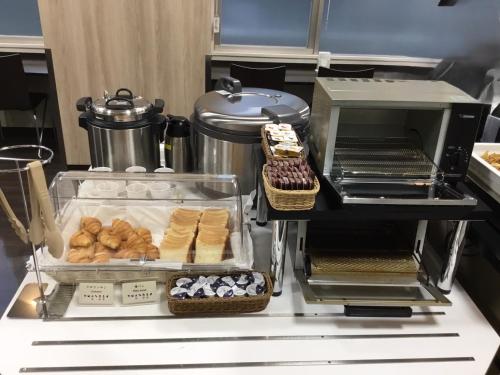 a counter with some pastries and other food items at Sanco Inn Yokkaichi Ekimae in Yokkaichi