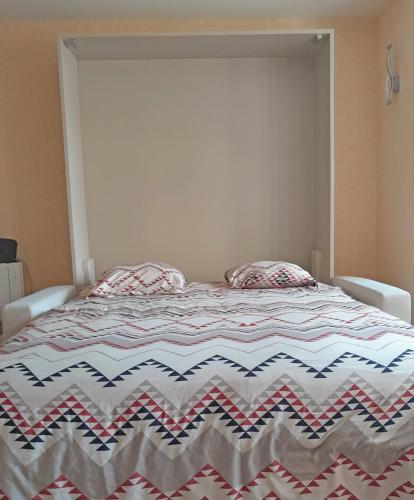- une chambre avec un lit et une couette à rayures dans l'établissement Charmant studio Deauville, proche plage avec parking privé, à Deauville