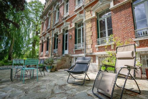 a group of chairs sitting outside of a building at Mille et une feuilles in Saint-Martin-lez-Tatinghem