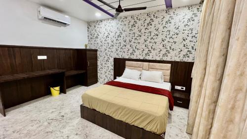 a bedroom with a bed and a brick wall at Hotel Soubhagya Inn PVT LTD in Silvassa