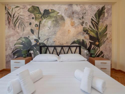ein Schlafzimmer mit einem großen weißen Bett und einem Wandbild in der Unterkunft I-Host Apartment - Lucania 12 in Mailand