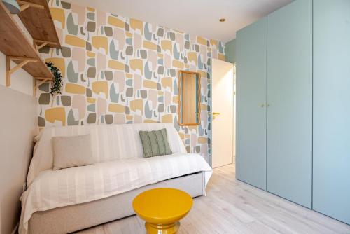 ein Wohnzimmer mit einem weißen Sofa und einem gelben Tisch in der Unterkunft Studio centre 10 min gare comedie in Montpellier