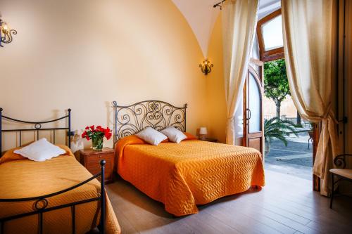 a bedroom with two beds and a large window at Relais Il Pennino in Massa Lubrense