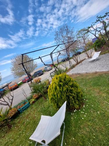 a group of white chairs sitting in the grass at Nautica apartments&studios in Peštani