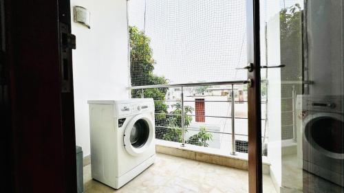a washing machine in a room with a window at BluO 3BHK Safdarjung Enclave, Lift & Terrace Garden in New Delhi