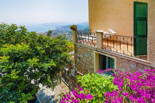 a building with a balcony with purple flowers at Dimora Concept -Ca' Lena - SeaView Terrace and Parking in Borgio Verezzi
