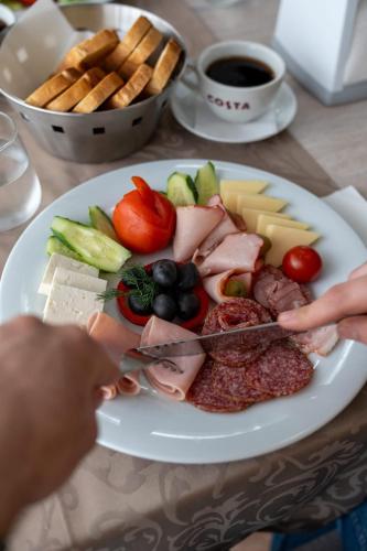 um prato de alimentos com carne e legumes sobre uma mesa em Complex Balnear Cozia - Corp Caciulata em Călimăneşti