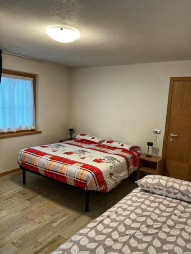 a bedroom with two beds and a window at Residence Raethia tra Bormio e Livigno in Valdidentro