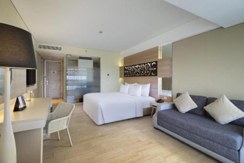 a hotel room with a bed and a couch at Anathera Resort Kuta in Kuta