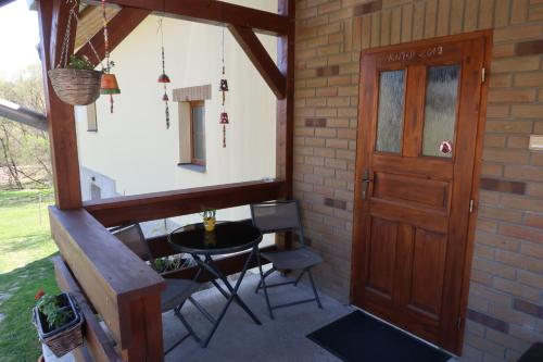 a porch with a door and a table and chairs at chalupa Vadčice in Dehtáře