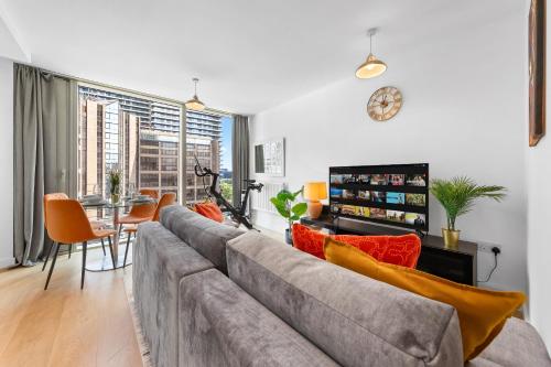 a living room with a gray couch and a table at Canary Wharf Apartment in London