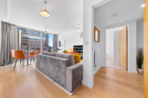 a living room with a gray couch and a table at Canary Wharf Apartment in London