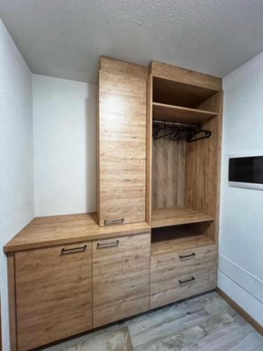 a large wooden cabinet in a kitchen next to a refrigerator at Residence Raethia tra Bormio e Livigno in Valdidentro